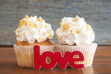 Wall Mural - Cupcake and word Love on wooden table.