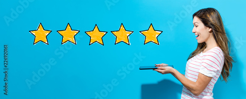 Fotografering Five star rating with young woman using her tablet