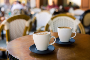 Cups of cappuccino with latte on wodden table.