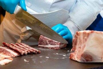 butcher or chef are cutting and decorating highest  meat grade of marbling A5 japanese wagyu beef for barbecue menu and sell in japanese restaurant or butcher shop in japan.