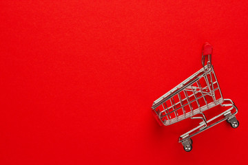 shopping trolley on red background with some copy space