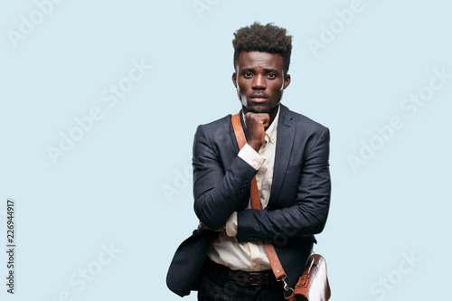Fotografie, Tablou young black businessman with a goofy, dumb, silly look, feeling shocked and confused at a recent realization, not really understanding an idea