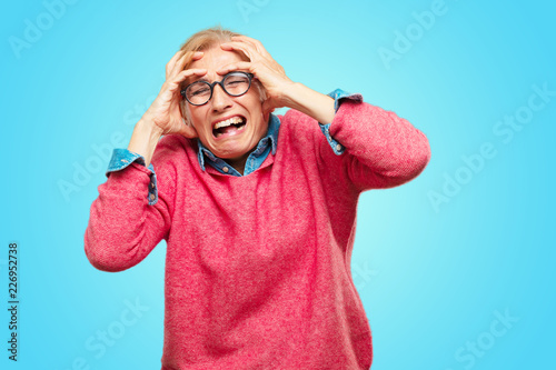 Fotografía Beautiful adult blonde woman with a crazy, amazed look of surprise, holding head with both hands, pulling hair