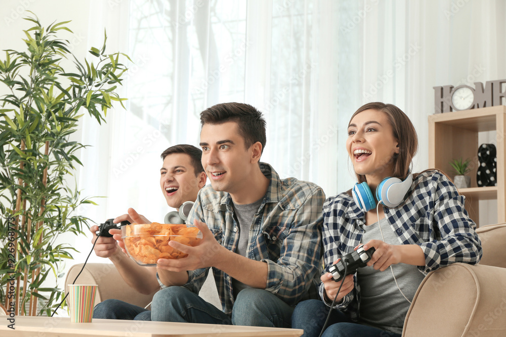 Young people playing video games at home