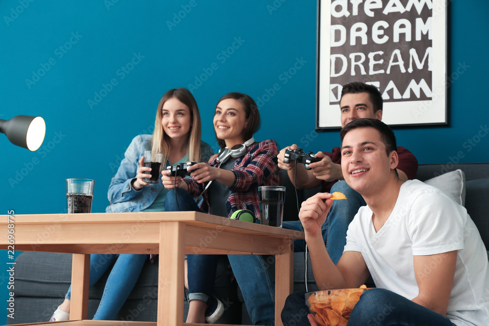Young people playing video games at home