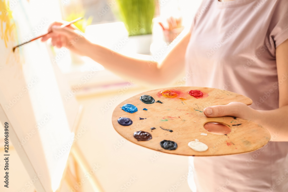 Female artist painting picture in workshop