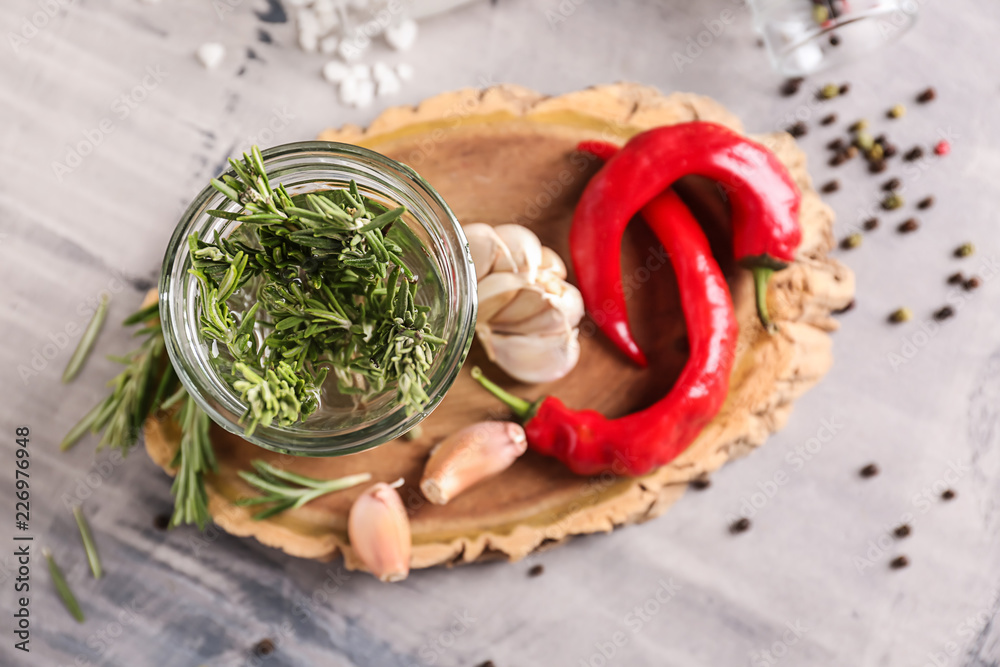 Jar with fresh rosemary on wooden board