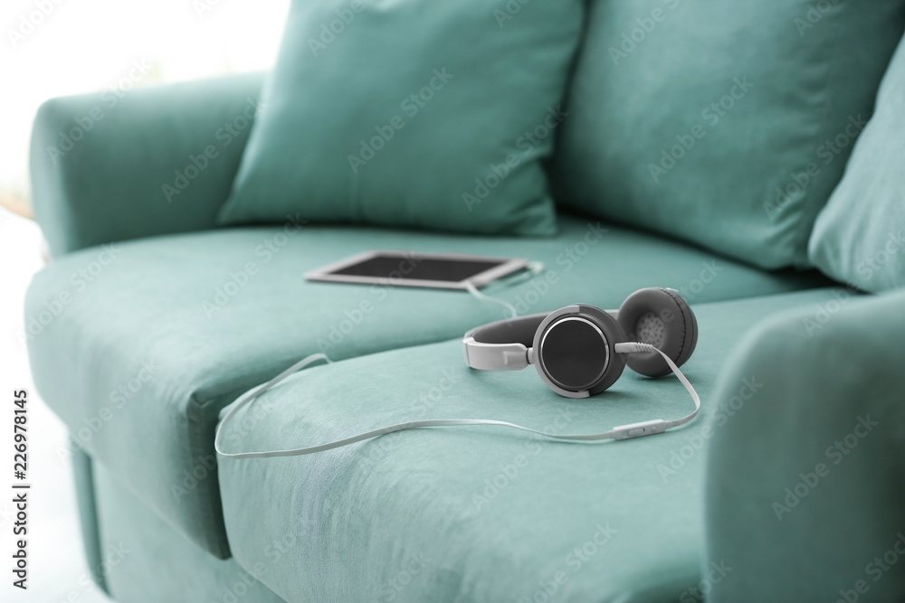 Headphones with tablet PC on sofa