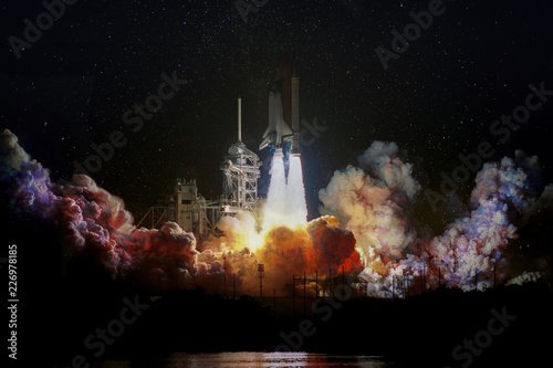 Fotomural Spaceship launch at night, landscape with colorful smoke clouds and galaxy background