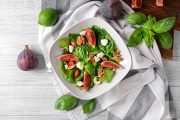 Wall Mural - Plate with delicious fig salad on light wooden table