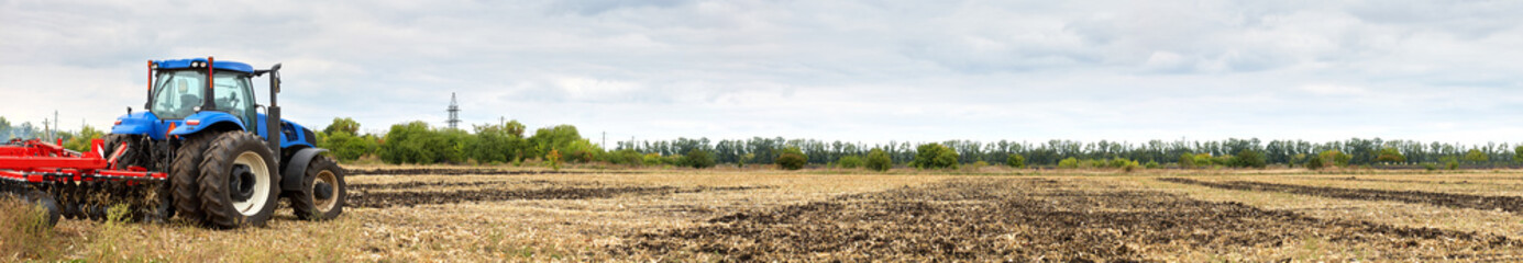 Poster - Tractor with disc harrow working in the field
