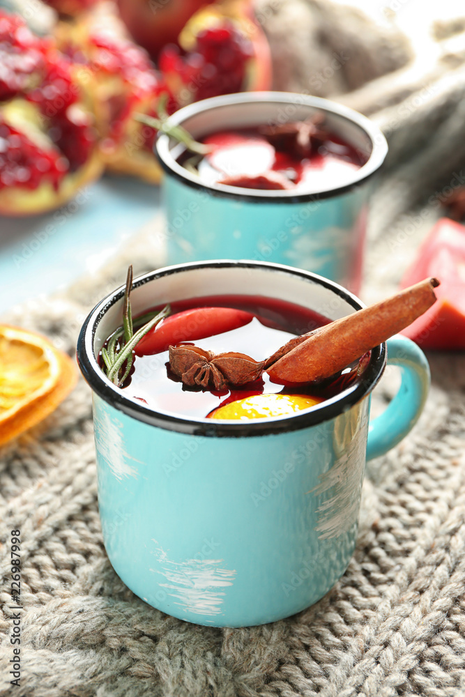 Metal cup of delicious mulled wine on warm plaid
