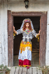 Wall Mural - beautiful girl in a hut in national Slavic costume