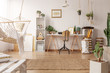 © Photographee.eu - Real photo of bright room interior with hammock, fresh plants and home office corner with wooden desk, chair and decor
