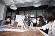 © Nattanon - Group of young modern people in casual wear planning business strategy. Business team analyzing income charts and graphs. Setup studio shooting.