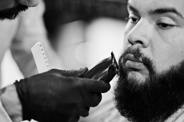 Wall Mural - Handsome bearded man at the barbershop, barber at work.