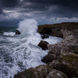 Dramatic nature background - big waves and dark rock in stormy sea, stormy weather. Dramatic scene. Contrasting colors.Beautiful natural landscape, seascape at Tyulenovo, Bulgaria. 
