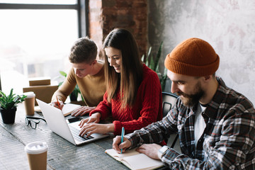 Group of university students learning languages using laptop  and internet. Exam preparation. Online education concept. Creative team of coworkers brainstorming. Meeting. Strategy planning. Teamwork. 