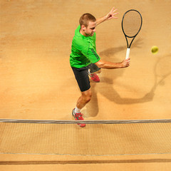 I am saving this ball now. Player lunge, game of defense. The one caucasian fit man playing tennis at the earthen court . Player jumping in full length with racquet and ball. Emotions on face. Upper