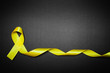 © andrey_orlov - childhood cancer awareness day. Yellow ribbon on black background.