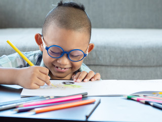 Boy intend drawing a picture fun, enjoy drawing or write in book at home.  .