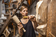 © Westend61 - Sculptress carving wooden figure in workshop