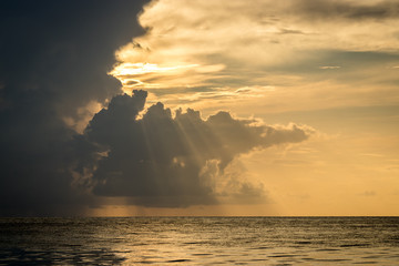 rayos de sol entre nubes cayendo sobre el mar al amanecer