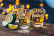 Shot of tequila with lime and salt on bokeh background