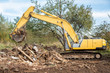 Yellow excavator removing construction debris