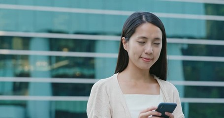 Poster - Woman use of smart phone and smile to camera with the office building background