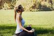 © Olesia - Girl meditates while practicing yoga outdoors in park