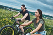 A man and a woman are laughing and cycling. Close up view