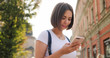 © VAKSMANV - Portrait of young positive girl using modern smartphone device t