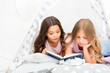 Girls best friends read fairy tale before sleep. Best books for kids. Children read book in bed. Reading before bed can help sleep better at night. Stories every kid should read. Family tradition
