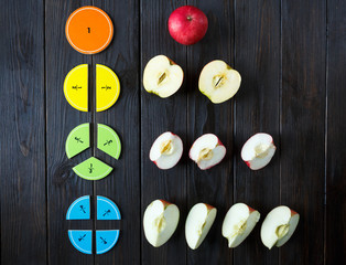 Wall Mural - colorful math fractions and apples as a sample on brown wooden background or table. interesting math for kids. Education, back to school concept. Geometry and mathematics materials.