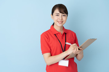 Wall Mural - portrait of young asian woman wearing red polo shirts on blue background