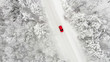 rotes Auto auf einer schneebedeckten eisigen Straße im Winter von oben, Luftbildaufnahme
