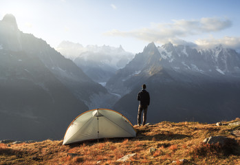 Wall Mural - hiker enjoying the view and a cup of coffee at his campsite on the famous tour du mont blanc.
