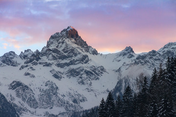 Wall Mural - Beautiful evening sunset view of mountain tops with snow and vibrant clouds in the Brandnertal in the Alps in Vorarlberg, Austria, in winter