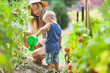 Cute toddler helphing mom in the garden