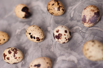 Canvas Print - Scattered lot of spotted fresh quail eggs on old broken worn gray cement floor