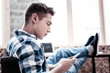 © zinkevych - Reading messages. Concentrated young man thoughtfully looking at the screen of his smartphone while reading messages