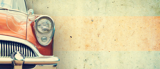 the headlight of the old beautiful car on the background of a concrete wall. copy space. concept ban