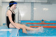 © zayatssv - swimming lessons for children in the pool - portrait of a beautiful white-skinned girl in a bathing suit and swim cap