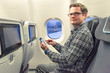 Mann checkt noch schnell seine Mails am Smartphone, bevor das Flugzeug abhebt