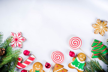 Various traditional colorful sugar glazed christmas gingerbread cookies, on white background top view copy space banner with xmas decorations