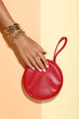 © 5second - Female hand with bracelets and red handbag on colorful background