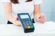 Seller holds payment terminal in hands. Contactless payment with nfc technology at shop, clinic, hotel. Mobile payment PayPass. Selective Focus on hands. Copy space.