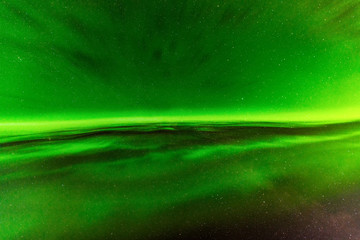 close up high definition photo of very bright green aurora with stars shining behind it, taken in no