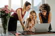 © Jacob Lund - Three businesswomen looking at laptop and smiling